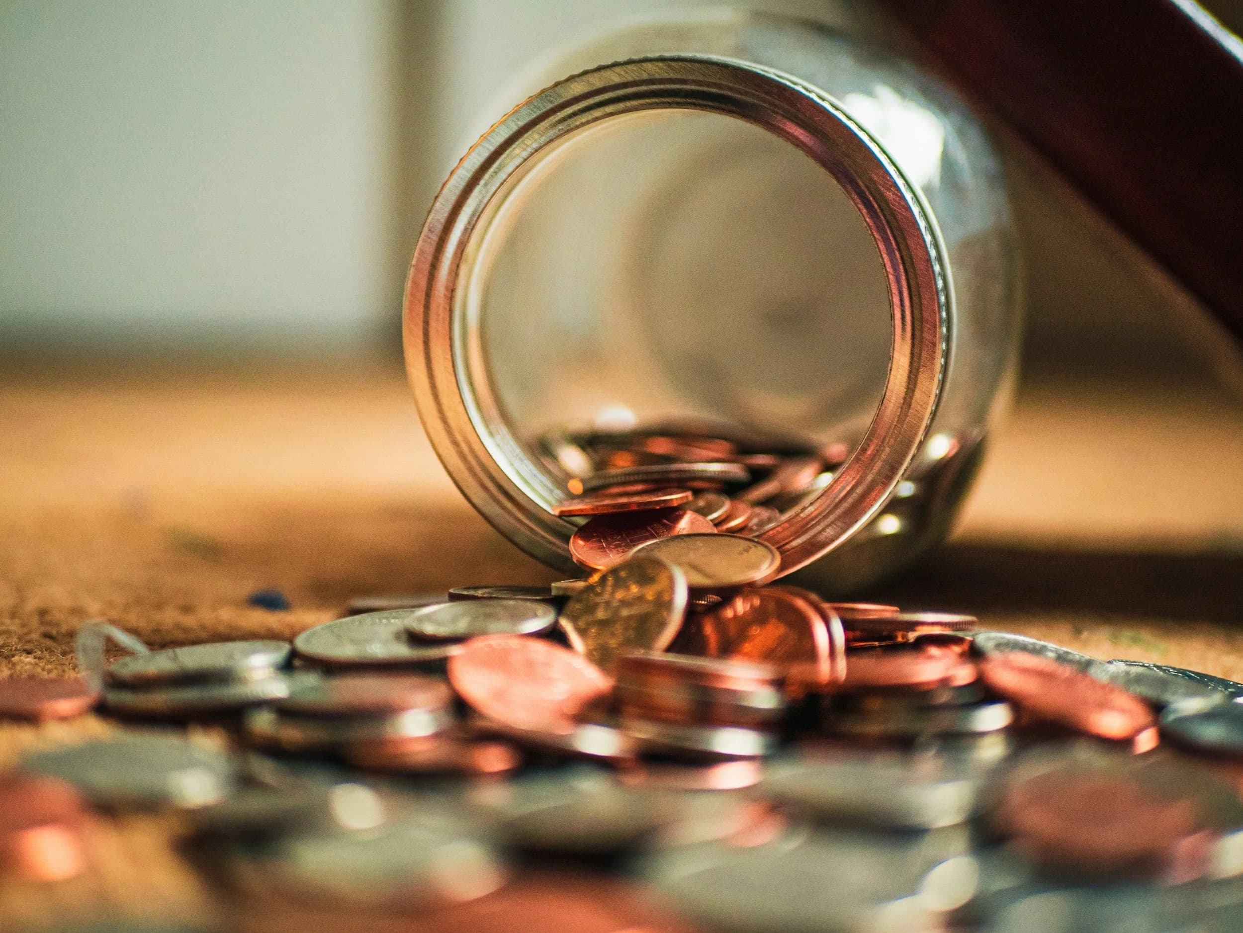Coins spilling from a jar representing bootstrapped startup capital