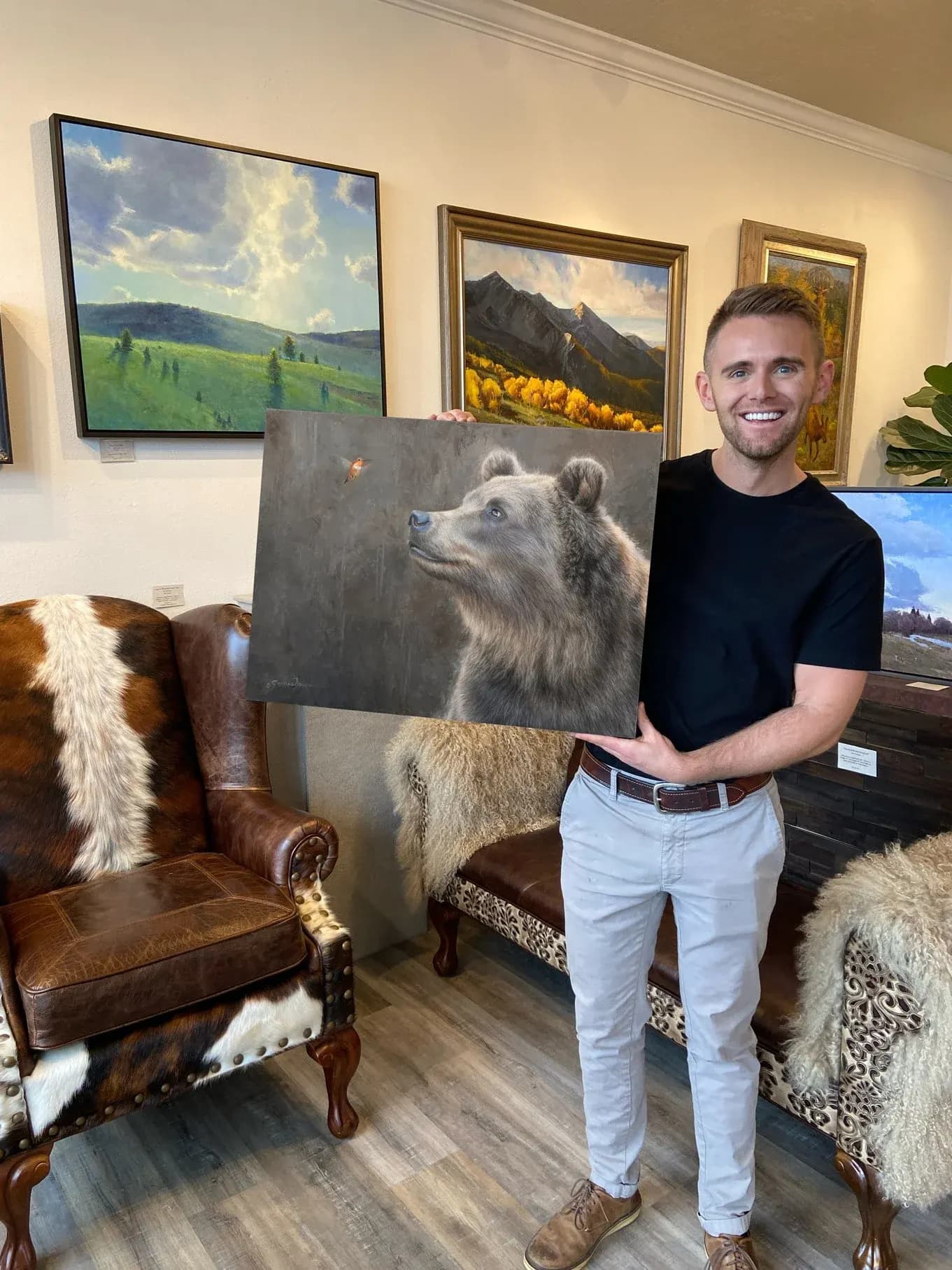 James Corwin holding a wildlife painting in Corwin Galleries