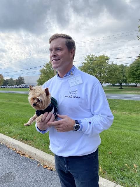 Russell Breuer holding a dog outside the Spot and Tango facility in Allentown, PA
