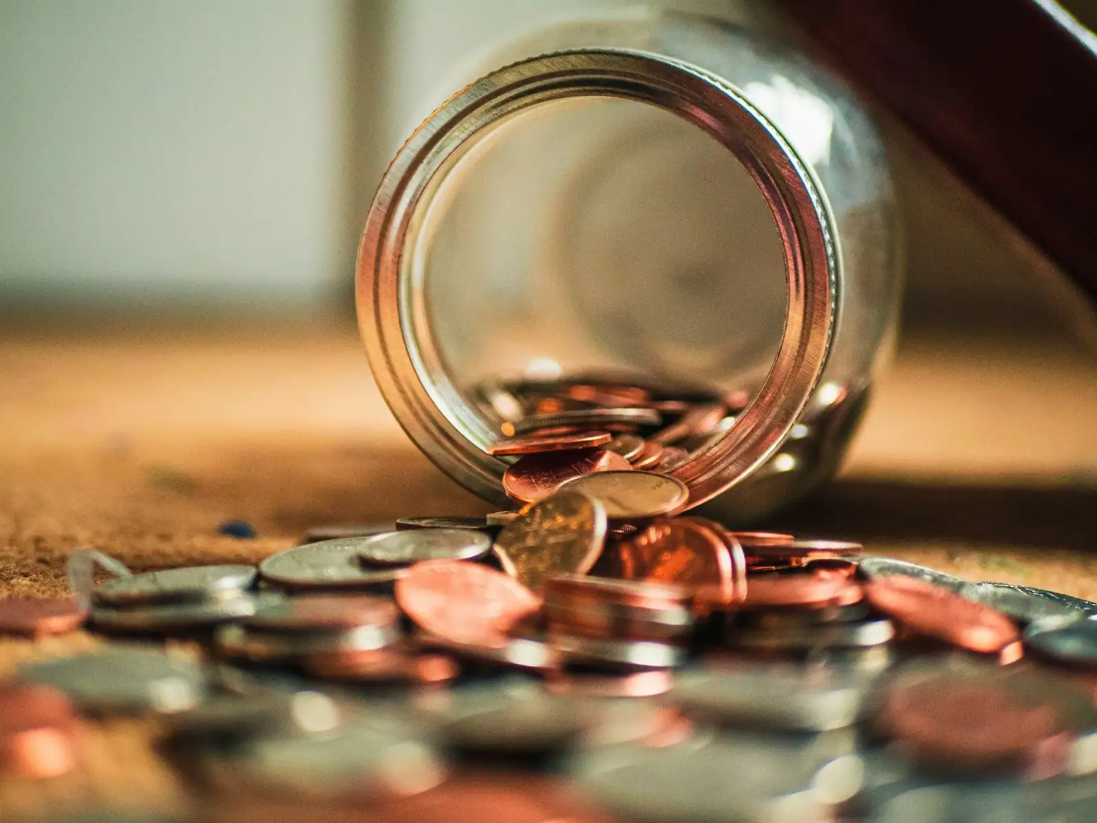 Coins spilling from a jar representing bootstrapped startup capital