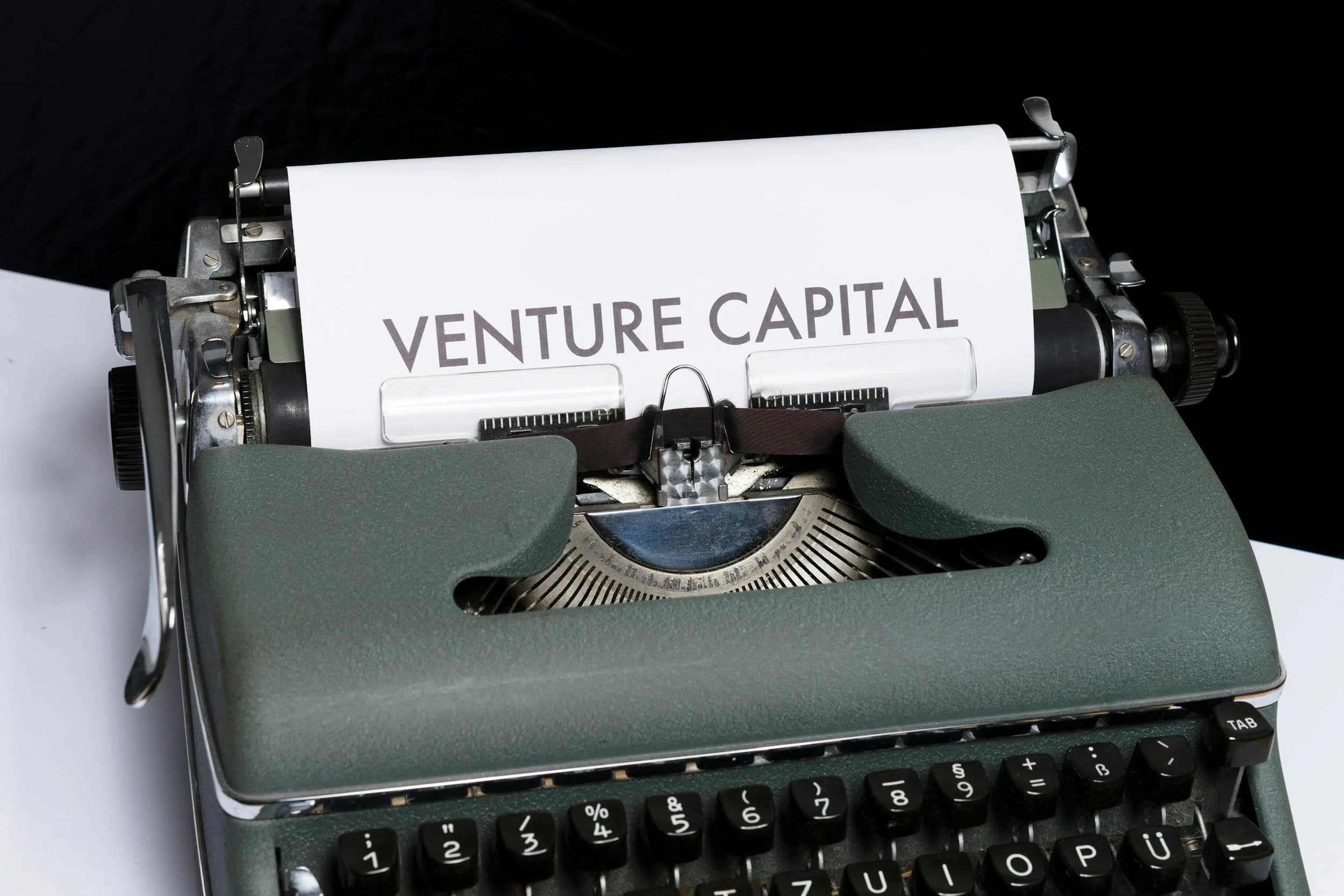 Typewriter with 'VENTURE CAPITAL' text — startup fundraising and equity dilution